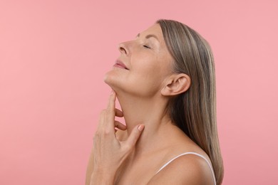 Beautiful woman with healthy skin on pink background