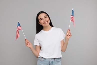 4th of July - Independence Day of USA. Happy woman with American flags on light grey background