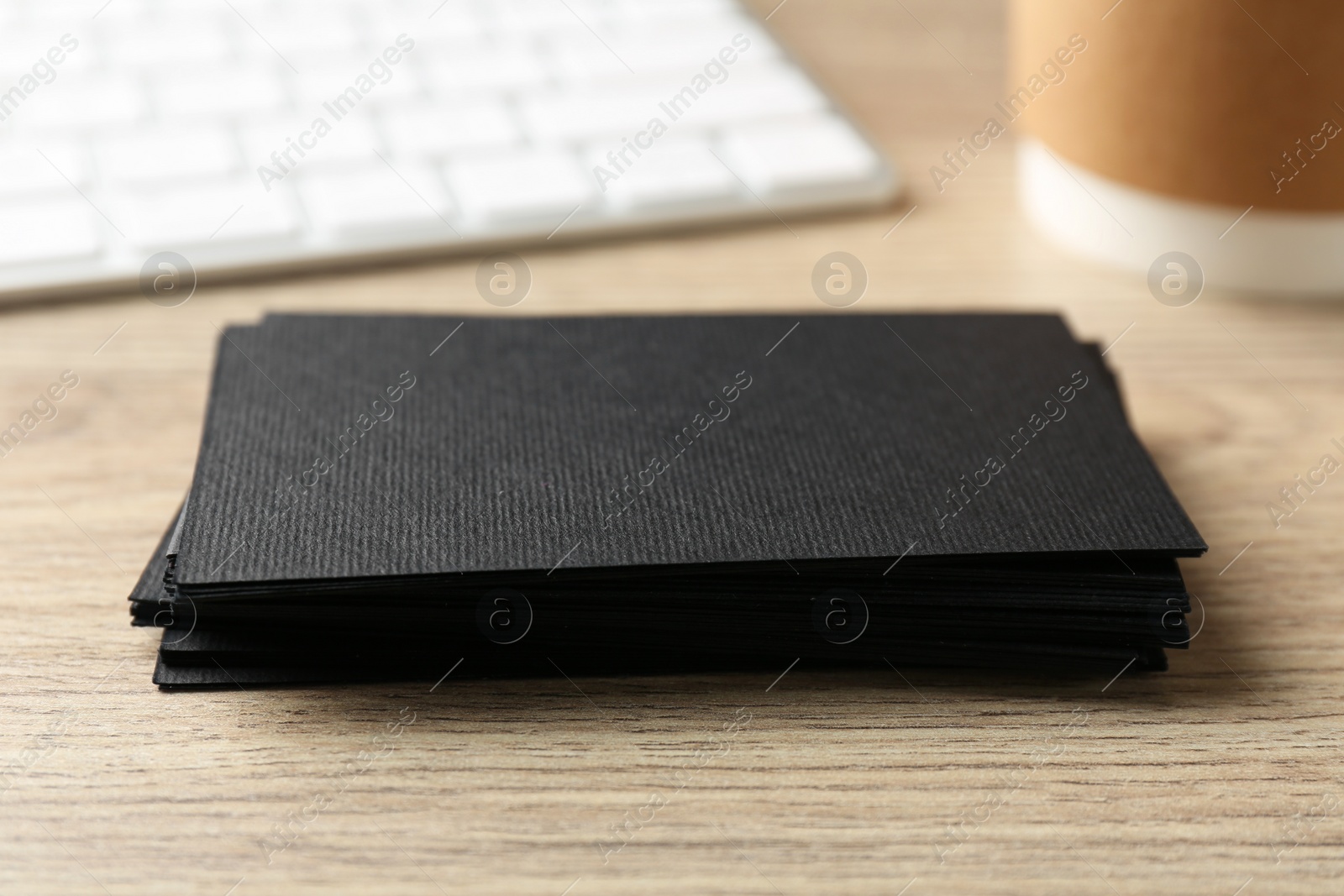 Photo of Blank black business cards on wooden table, closeup. Mockup for design