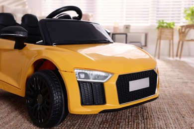 Photo of Yellow car in room at home, closeup. Child's toy