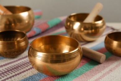 Tibetan singing bowls with mallets on colorful fabric