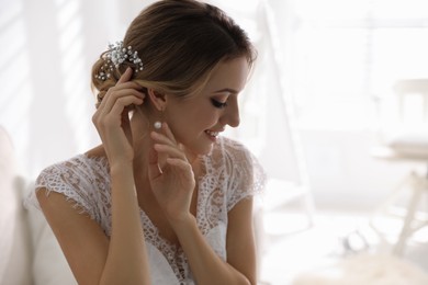 Photo of Young bride with elegant wedding hairstyle in room