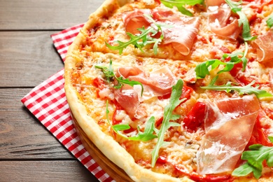 Photo of Tasty hot pizza with meat on wooden background