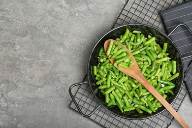 Flat lay composition with frozen green beans on grey background. Vegetable preservation