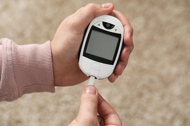 Photo of Diabetes test. Man with glucometer on blurred background, closeup