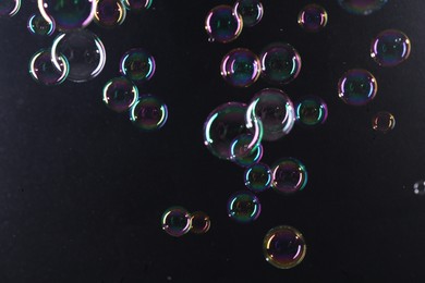 Photo of Beautiful transparent soap bubbles on dark background