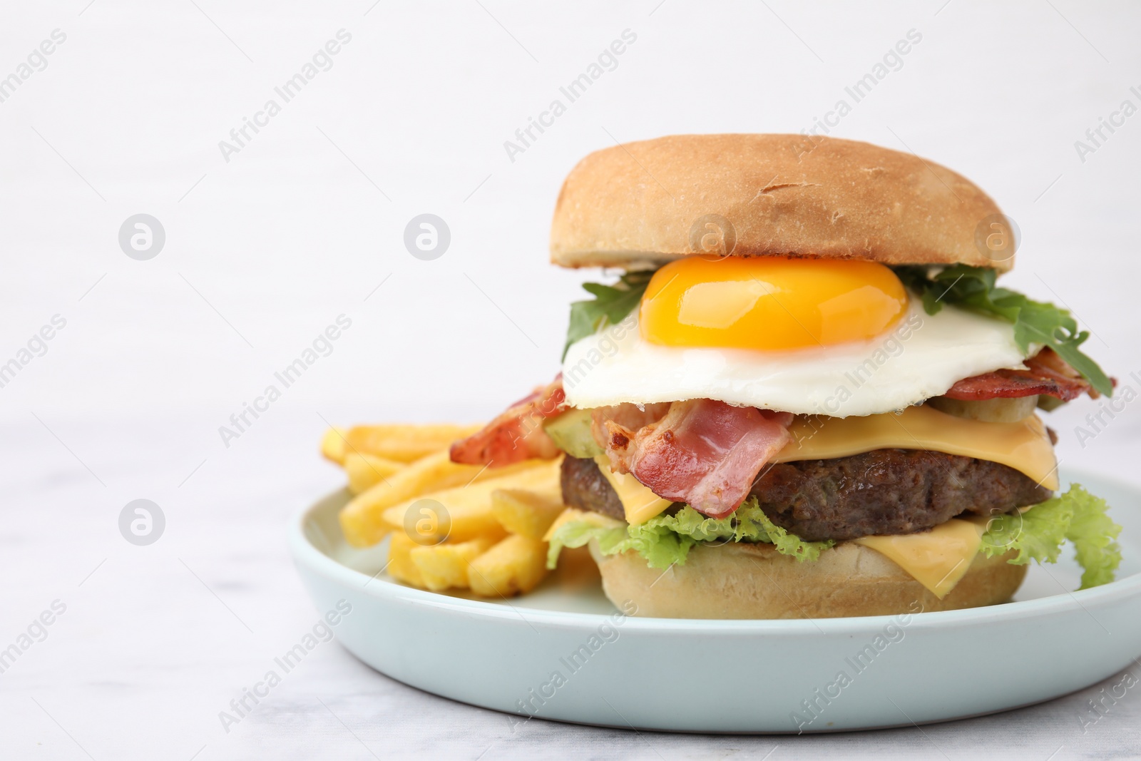 Photo of Delicious burger with fried egg and french fries served on white marble table, closeup. Space for text