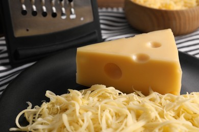 Grated and whole piece of cheese on table, closeup