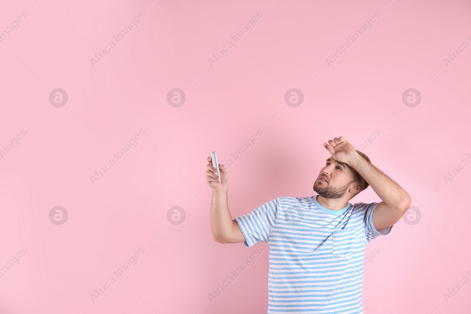 Photo of Young man suffering from heat on color background with copy space text. Air conditioner malfunction