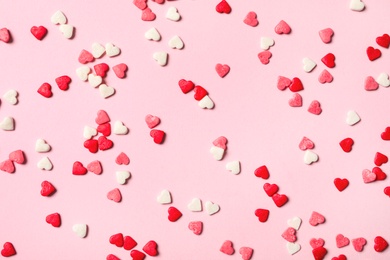 Photo of Heart shaped sprinkles on pink background, flat lay