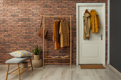 Photo of Hallway interior with stylish furniture, clothes and accessories