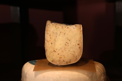 Photo of Delicious cheese in store, closeup. Dairy product