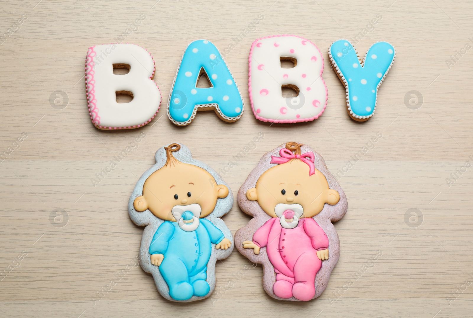 Photo of Word Baby made of tasty cookies on white wooden table, flat lay