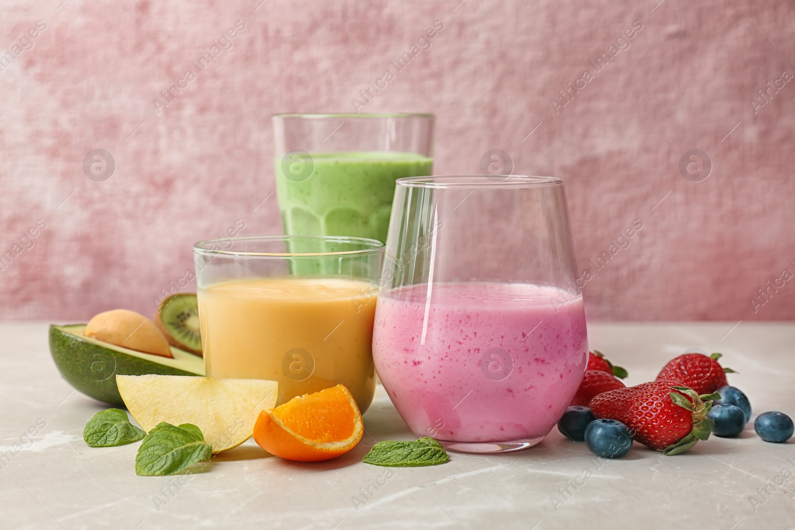 Photo of Glasses with healthy detox smoothies and ingredients on table