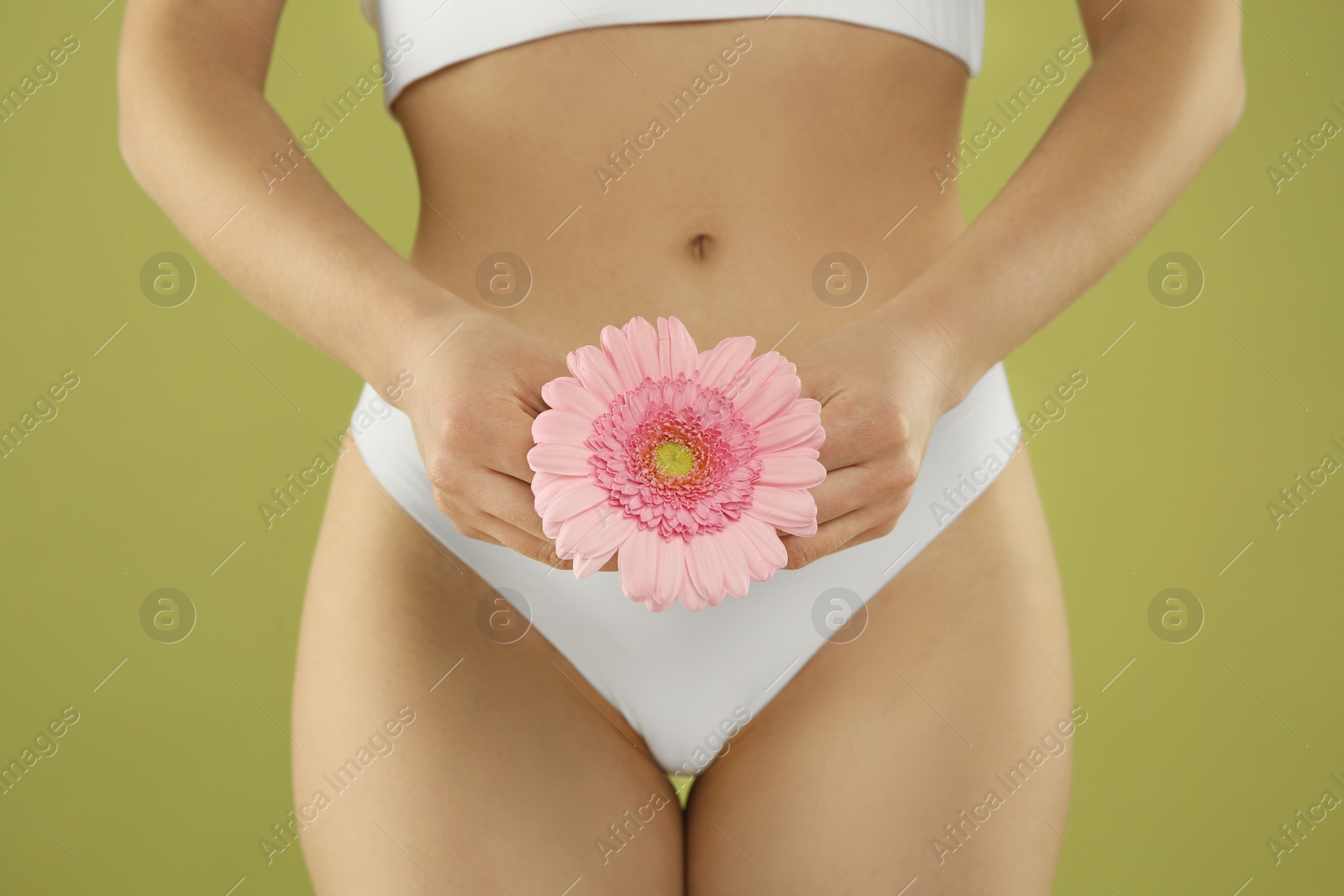 Photo of Gynecology. Woman in underwear with gerbera flower on green background, closeup