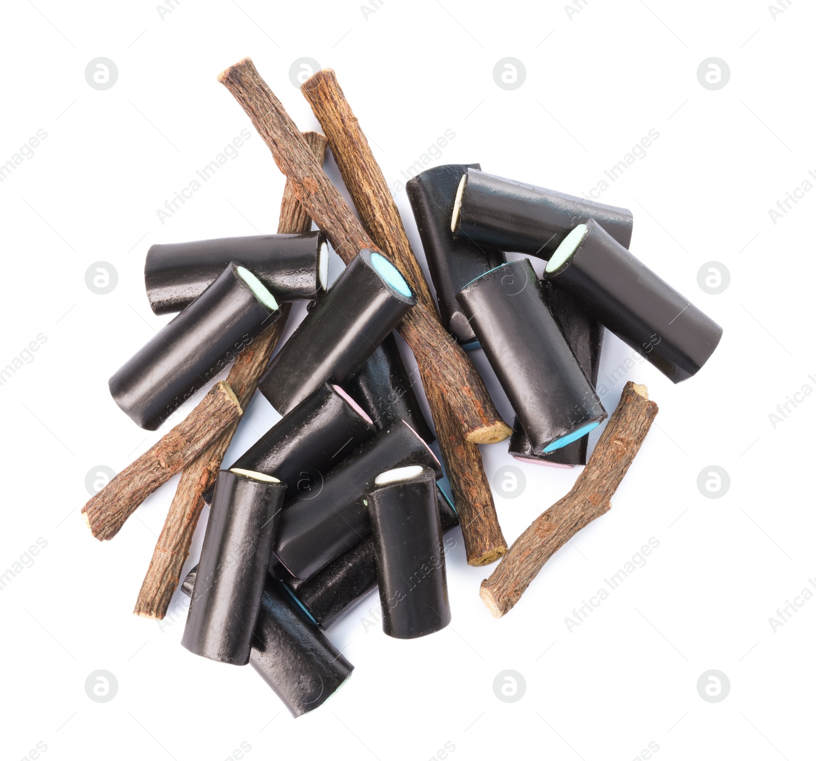 Photo of Many tasty candies and dried sticks of liquorice root isolated on white, top view