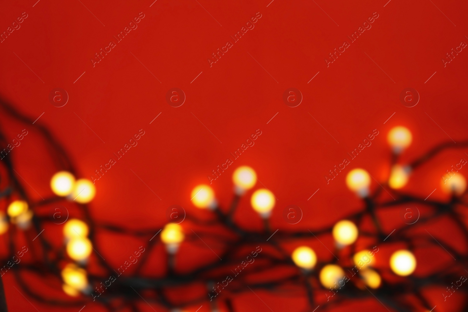 Photo of Blurred view of glowing Christmas lights on color background, top view