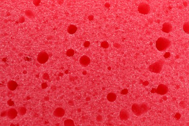 Red cleaning sponge as background, top view