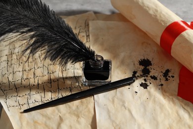 Photo of Inkwell with feather, fountain pen and vintage parchment