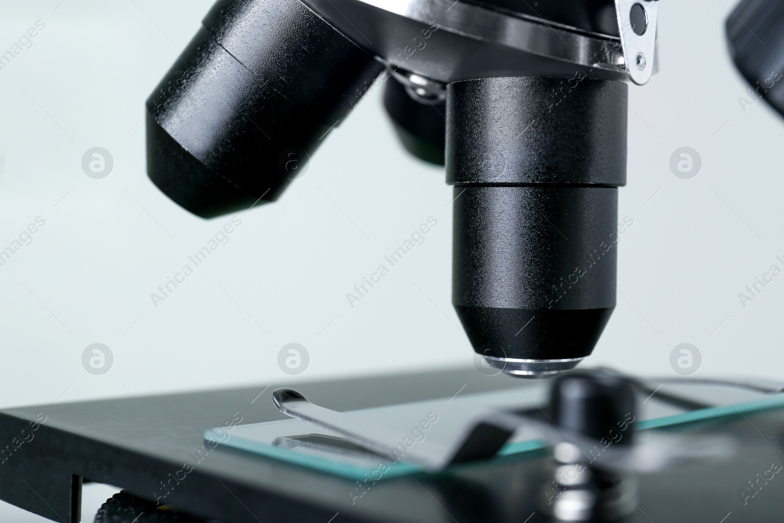 Photo of Modern medical microscope with glass slide on grey background, closeup