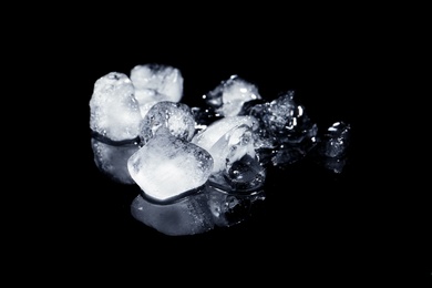 Photo of Melting ice cubes on black background. Frozen liquid