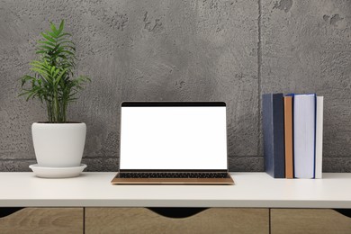 Photo of Workplace with modern laptop on table. Mockup for design