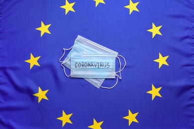 Photo of Protective masks on European Union flag background, top view. Coronavirus outbreak