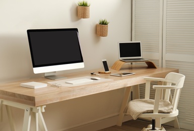 Stylish workplace interior with modern computer on table. Mockup for design