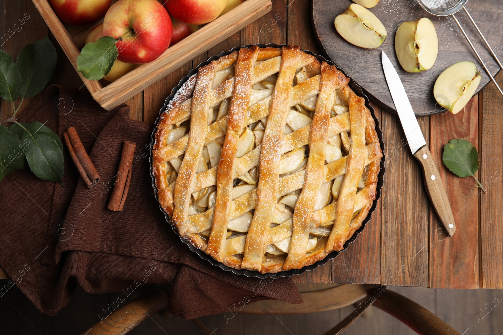 Photo of Delicious traditional apple pie on wooden table, flat lay