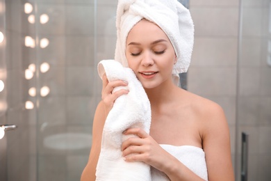 Photo of Beautiful woman with clean towels in bathroom