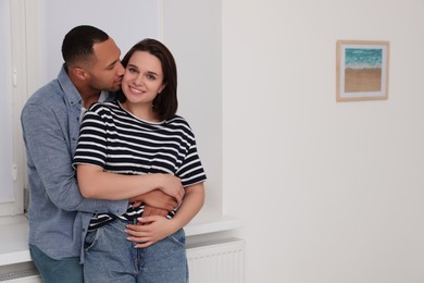 Dating agency. Couple hugging near window at home, space for text