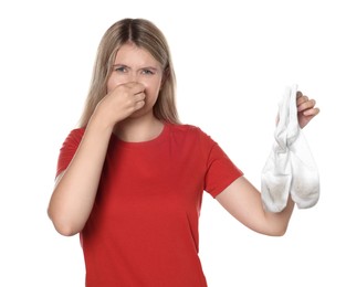 Photo of Young woman feeling bad smell from dirty socks isolated on white