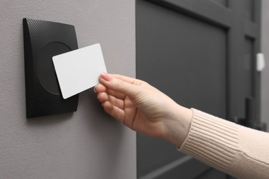 Photo of Woman opening magnetic door lock with key card, closeup. Home security