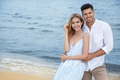 Happy couple on beach, space for text. Romantic walk