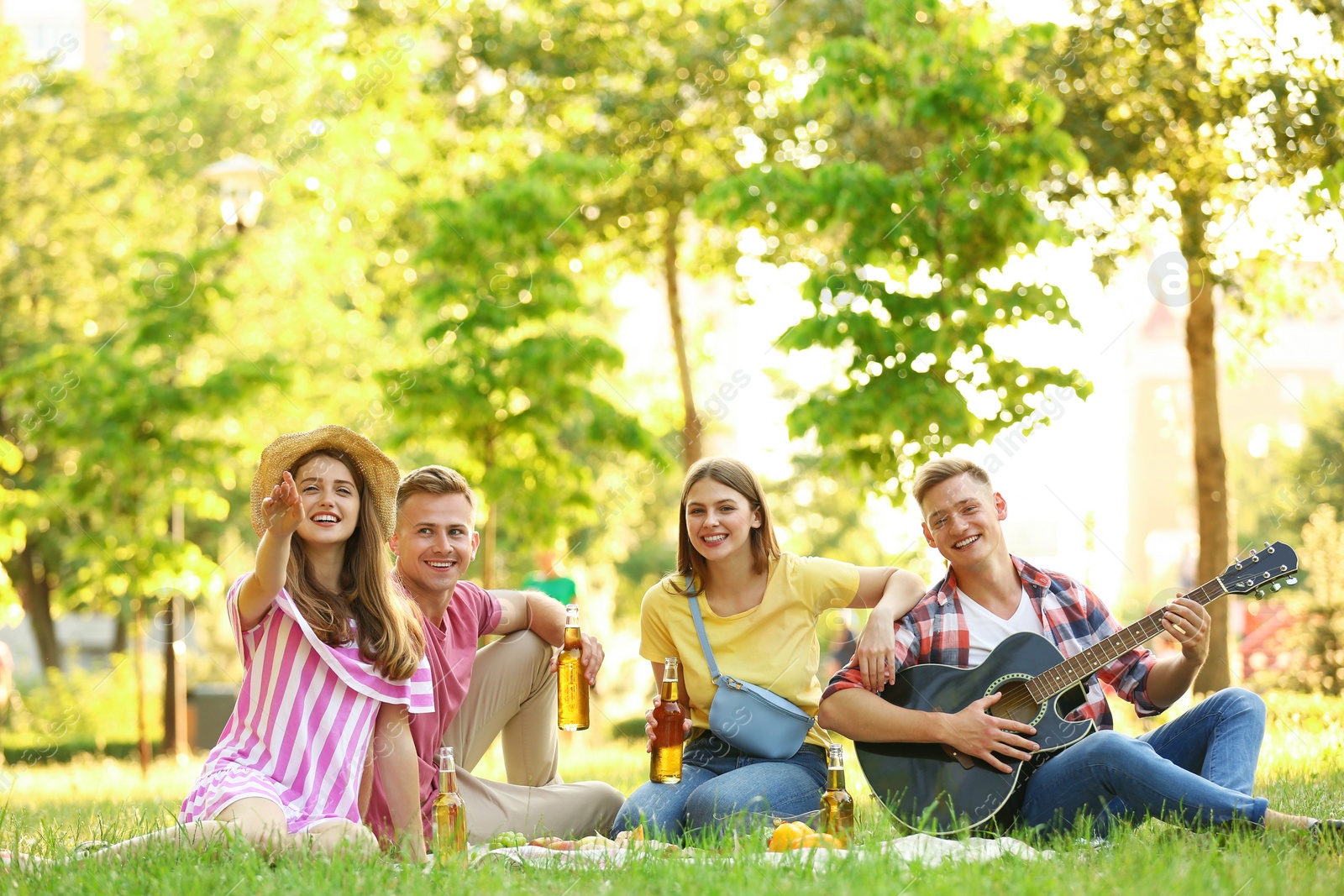 Photo of Young people enjoying picnic in park on summer day