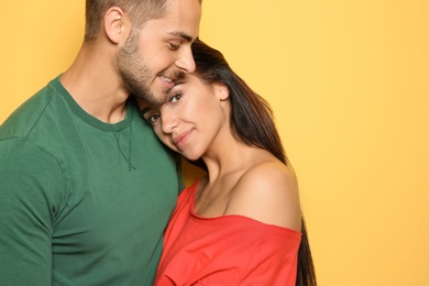 Photo of Young happy couple in trendy clothes on yellow background