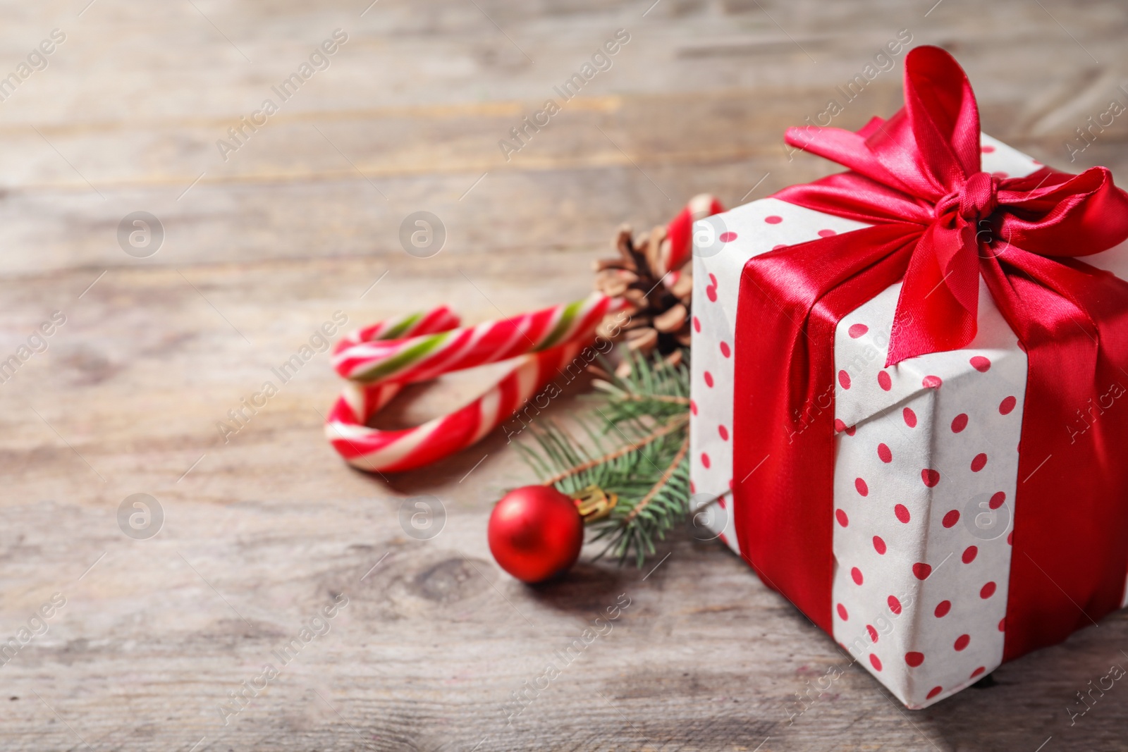 Photo of Beautiful composition with gift box and Christmas decorations on wooden table