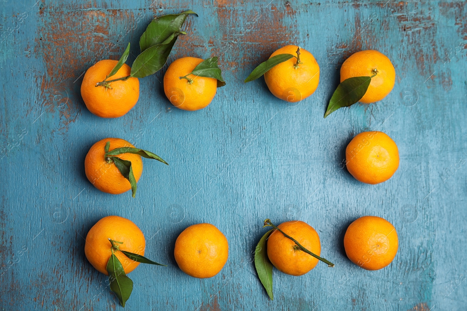 Photo of Fresh ripe tangerines and space for text on wooden background, top view