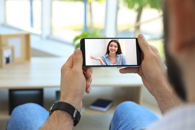 Image of Man talking with beautiful woman using video chat on smartphone indoors, closeup. Online dating