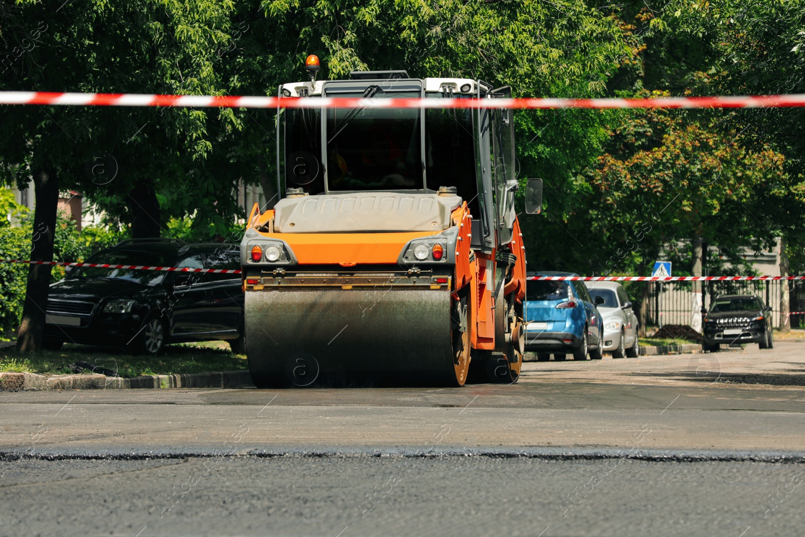 Photo of Roller working on city street. Road repairing