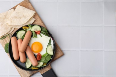 Photo of Delicious breakfast with boiled sausages and fried egg on white tiled table, top view. Space for text