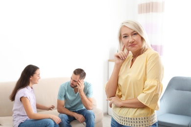 Young couple having argument in presence of mother-in-law at home. Family quarrel