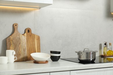 Photo of Wooden cutting boards and other cooking utensils on white countertop in kitchen