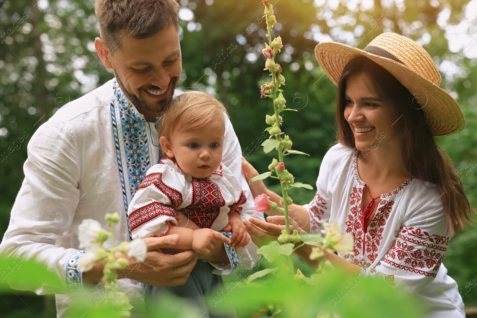 Photo of Happy family in Ukrainian national clothes outdoors