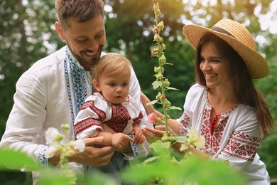 Photo of Happy family in Ukrainian national clothes outdoors