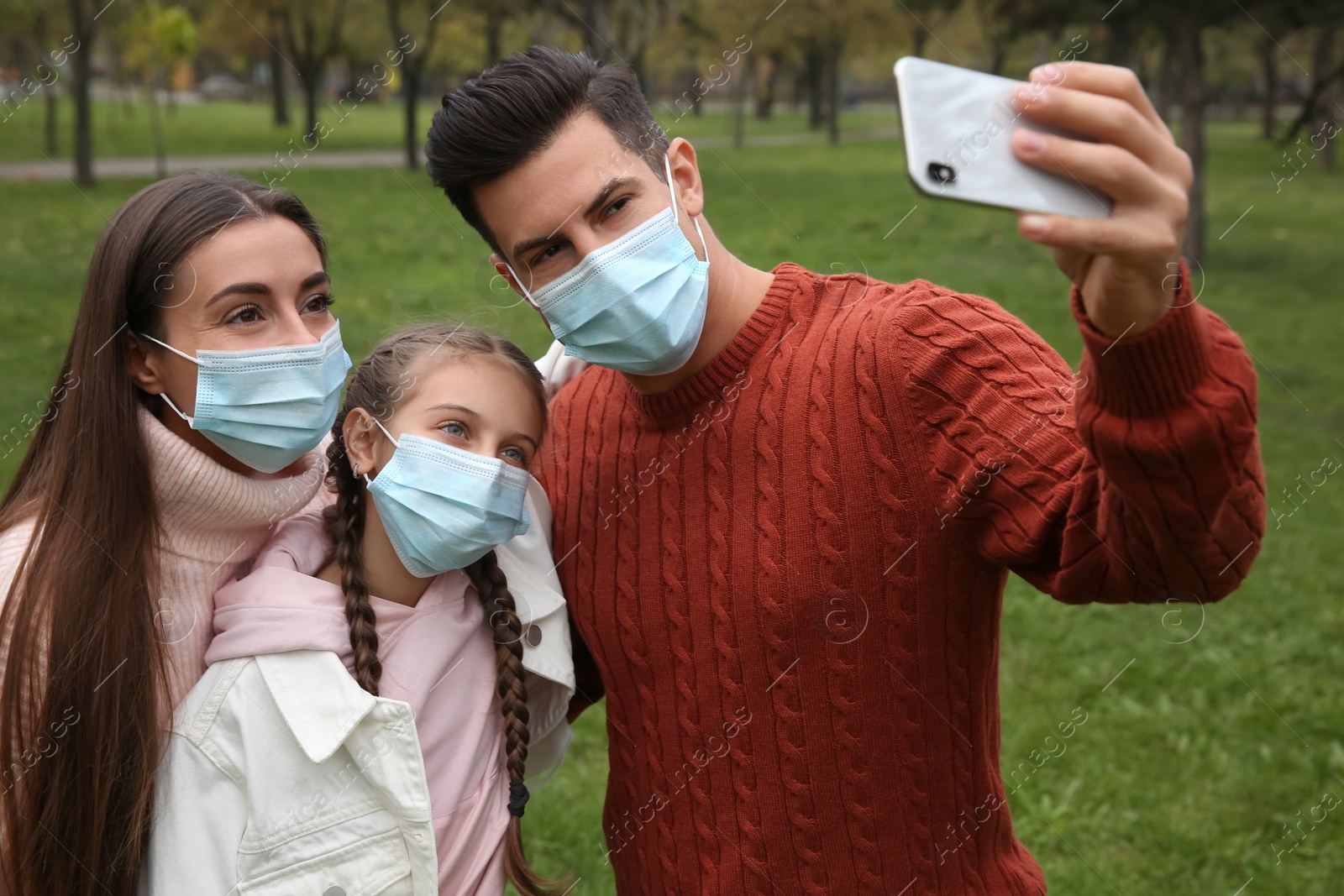 Photo of Lovely family taking selfie together in park during coronavirus pandemic