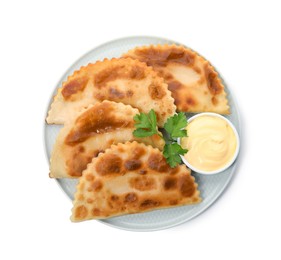 Photo of Delicious fried chebureki with sauce isolated on white, top view