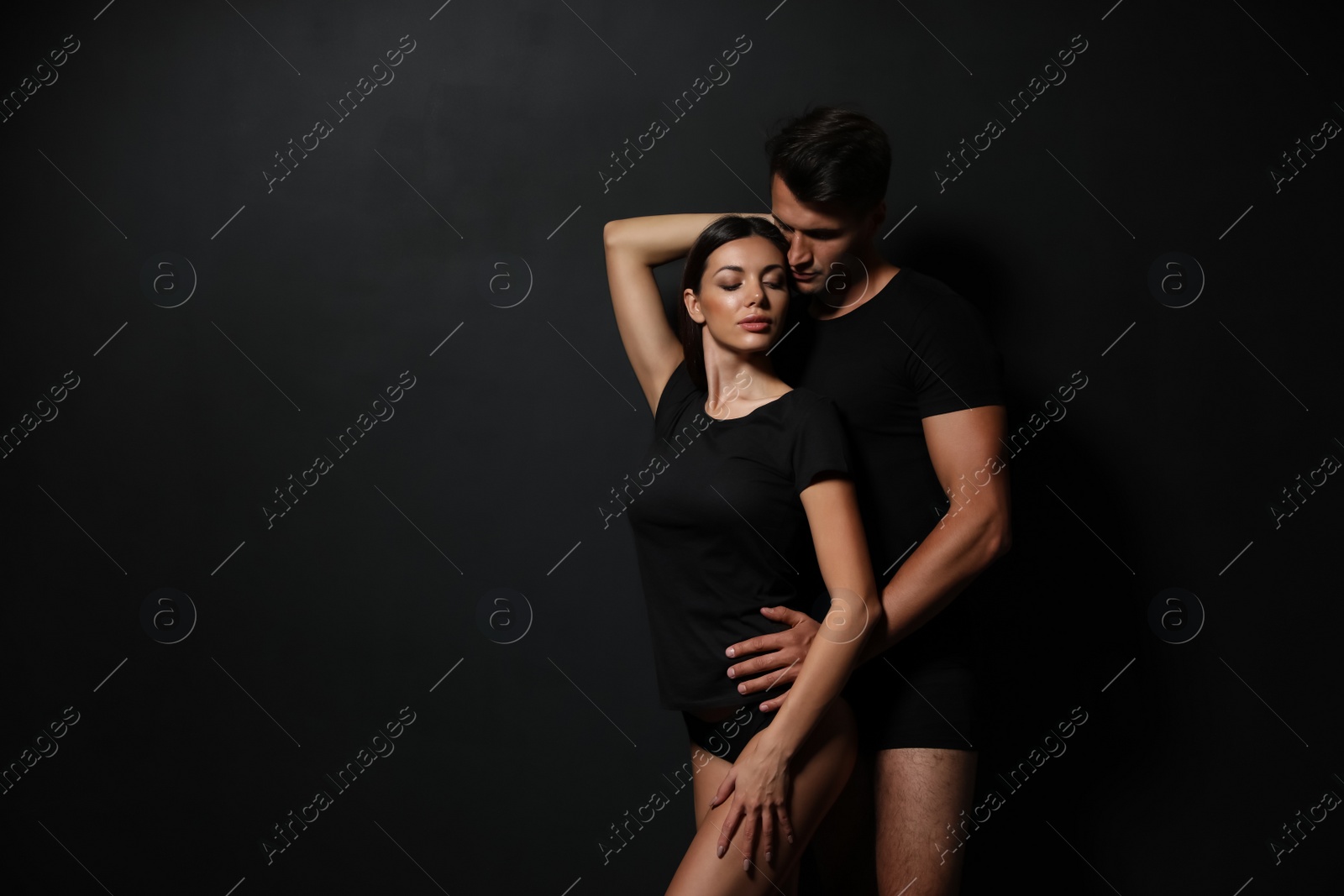 Image of Young couple wearing underwear on black background