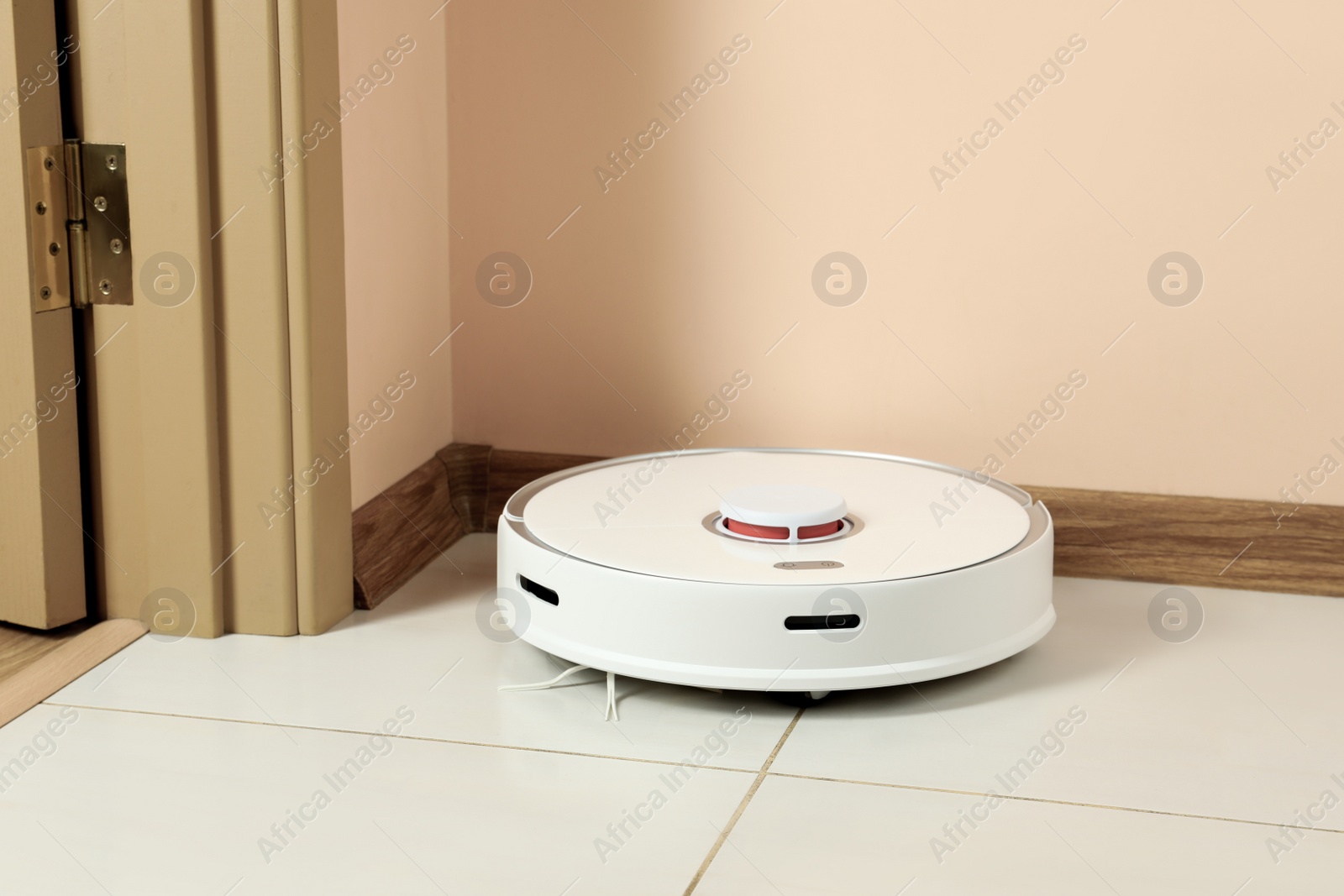 Photo of Modern robotic vacuum cleaner on white floor indoors