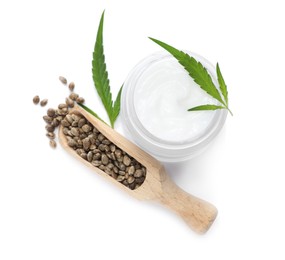 Photo of Jar of hemp cream, green leaves and scoop with seeds on white background, top view. Natural cosmetics